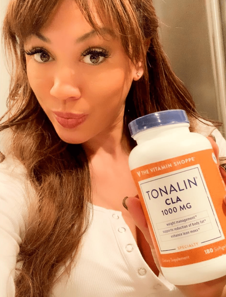 A woman holding up a bottle of tonalin cla.